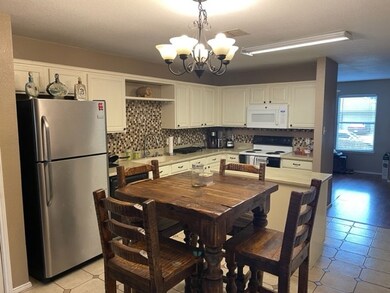 Dining area with a notable chandelier, light tile patterned floors, and visible vents