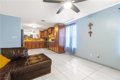 Living room featuring a ceiling fan and light tile patterned floors