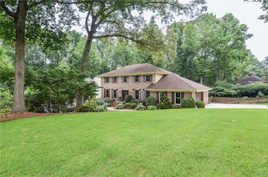 Colonial home with concrete driveway, a garage, and brick siding