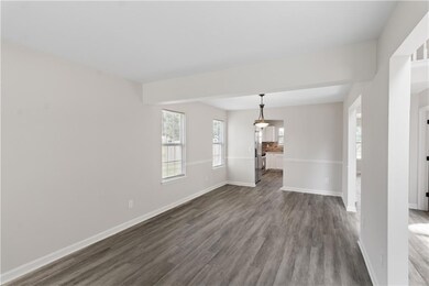 Unfurnished living room with dark wood finished floors and baseboards
