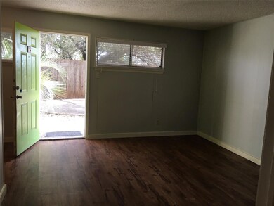Entrance foyer with dark wood-style flooring, a t