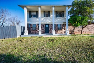 Neoclassical home featuring a front yard, fence, a
