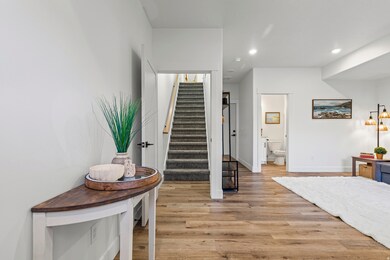 Entry, living room, garage access, and stairs to main living area.