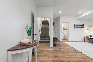 Entry, living room, garage access, and stairs to main living area.