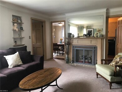 Living room with decorative fireplace opens into kitchen and dining rooms.
