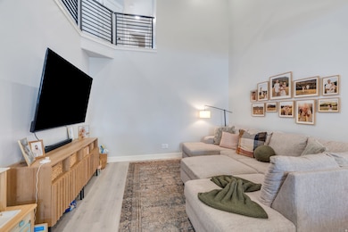 Living room with a towering ceiling and light wood-style flooring
