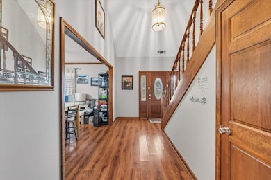 Entryway featuring stairway, wood finished floors, and a chandelier