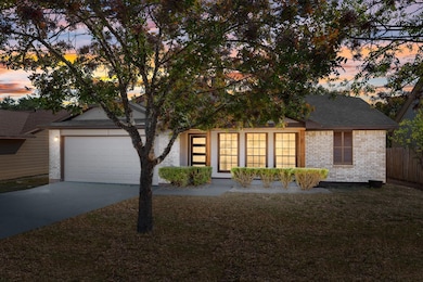 View of front of home with brick siding, concrete driveway, an attached garage, and roof with shingles
