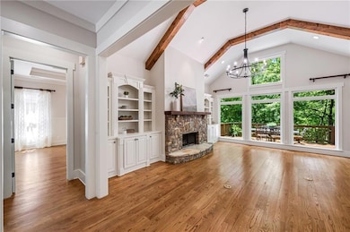 Unfurnished living room featuring a chandelier, wo