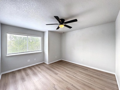 Unfurnished room with wood finished floors, a tex