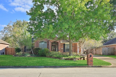 The well-maintained yard features a neat stone-bordered flower bed, creating a welcoming curb appeal