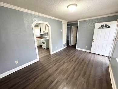 Unfurnished bedroom with a textured ceiling, dark 