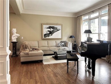 Living room featuring crown molding, ornate column
