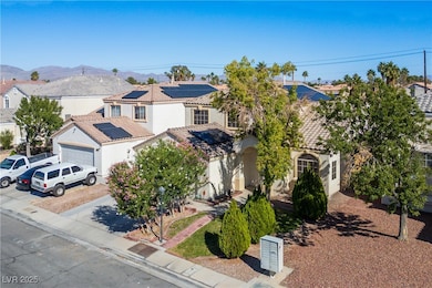 View of front facade featuring stucco siding, driveway, a residential view, a garage, and roof mounted solar panels