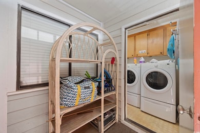 Laundry area featuring cabinet space and washer an