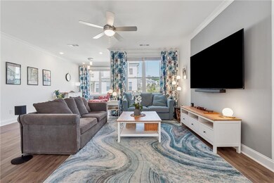 Living room featuring ornamental molding, wood finished floors, and ceiling fan