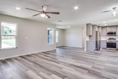 Unfurnished living room with ceiling fan and light