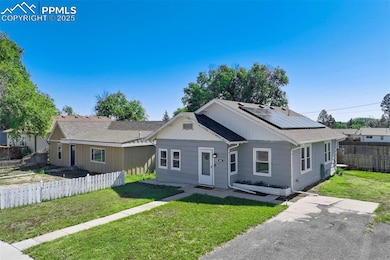 View of front of house featuring roof mounted solar panels and roof with shingles