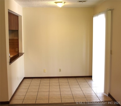 Dining area features tile, sliding door to carport