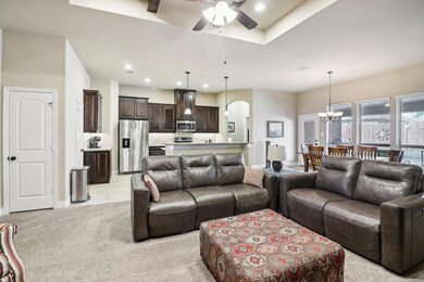 Living room with ceiling fan with notable chandeli