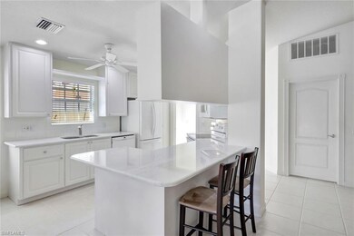 Kitchen with white appliances, a breakfast bar, a 