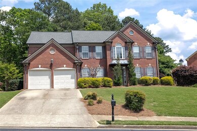 Colonial home with concrete driveway, brick siding