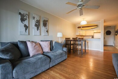 Living room with crown molding, ceiling fan, and l
