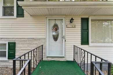View of exterior entry with stone siding and covered porch