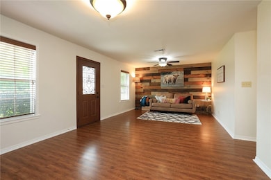 Unfurnished living room featuring ceiling fan, woo