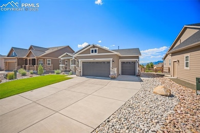 View of front of house featuring a garage, concrete driveway, stucco siding, stone siding, and a front lawn