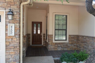 Property entrance with stone siding and stucco si