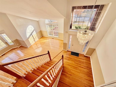 Entryway featuring high vaulted ceiling, light wood finished floors, healthy amount of natural light, and a chandelier
