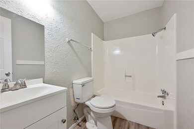 Full bath featuring wood finished floors, vanity,