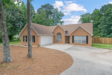 Ranch-style home with concrete driveway, a garage, roof with shingles, and brick siding