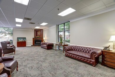 Carpeted living room with ornamental molding and a fireplace with raised hearth