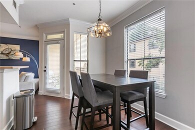 Dining area with a chandelier, ornamental molding, and dark wood-type flooring