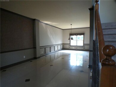 Empty room with a wainscoted wall, stairway, and ornamental molding
