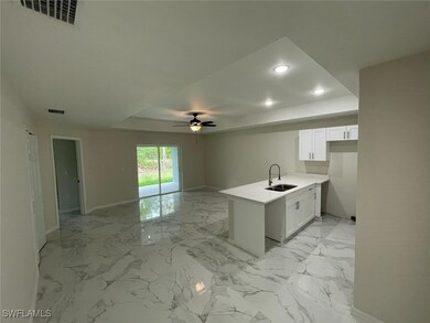 Kitchen with marble finish floor, a sink, a raised
