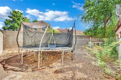 Fenced backyard featuring a trampoline