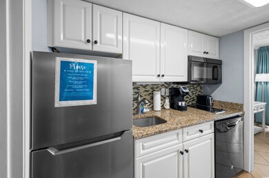 Kitchen with decorative backsplash, black applianc