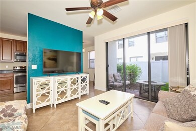 Living area featuring baseboards, ceiling fan, vis