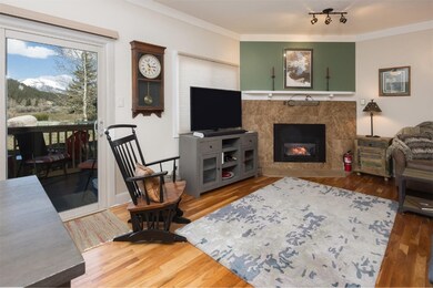 Living room featuring crown molding, wood flooring