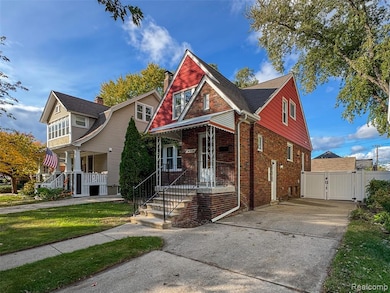 View of front of property with brick siding, a gate, concrete driveway, and covered porch