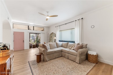 Living room featuring ceiling fan, light wood-type