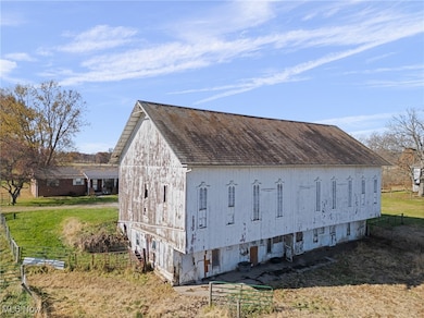 View of side of home featuring a barn and an outbuilding