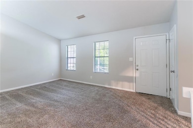 Carpeted spare room with baseboards