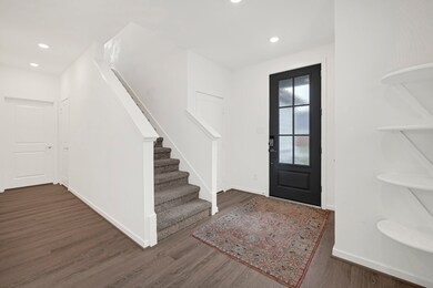 Welcoming foyer with glass-paneled black front doo