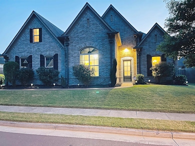French provincial home with a front yard and brick siding
