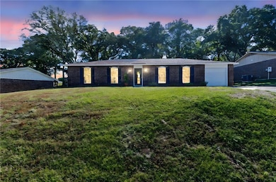 View of front of house featuring brick siding, a front lawn, and an attached garage