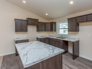 Kitchen with crown molding and raised cabinet abov